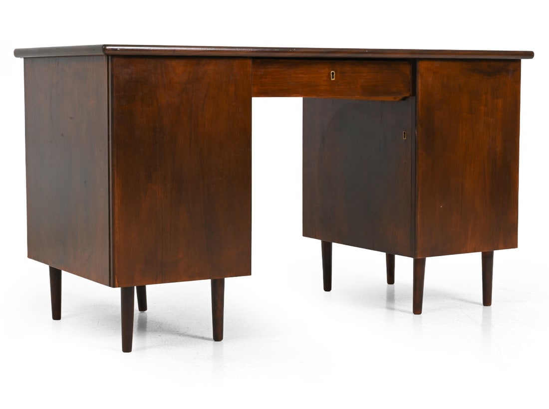 SCANDINAVIAN WALNUT WRITING DESK C. 1950S: Key included. Walnut veneer writing desk, with cabinet doors and drawers, featuring brass pulls. Scandinavian, circa 1950s. Dimensions: H 28.5" x W 51.5" x D 28.5" Condition: Fading and scuffs to top