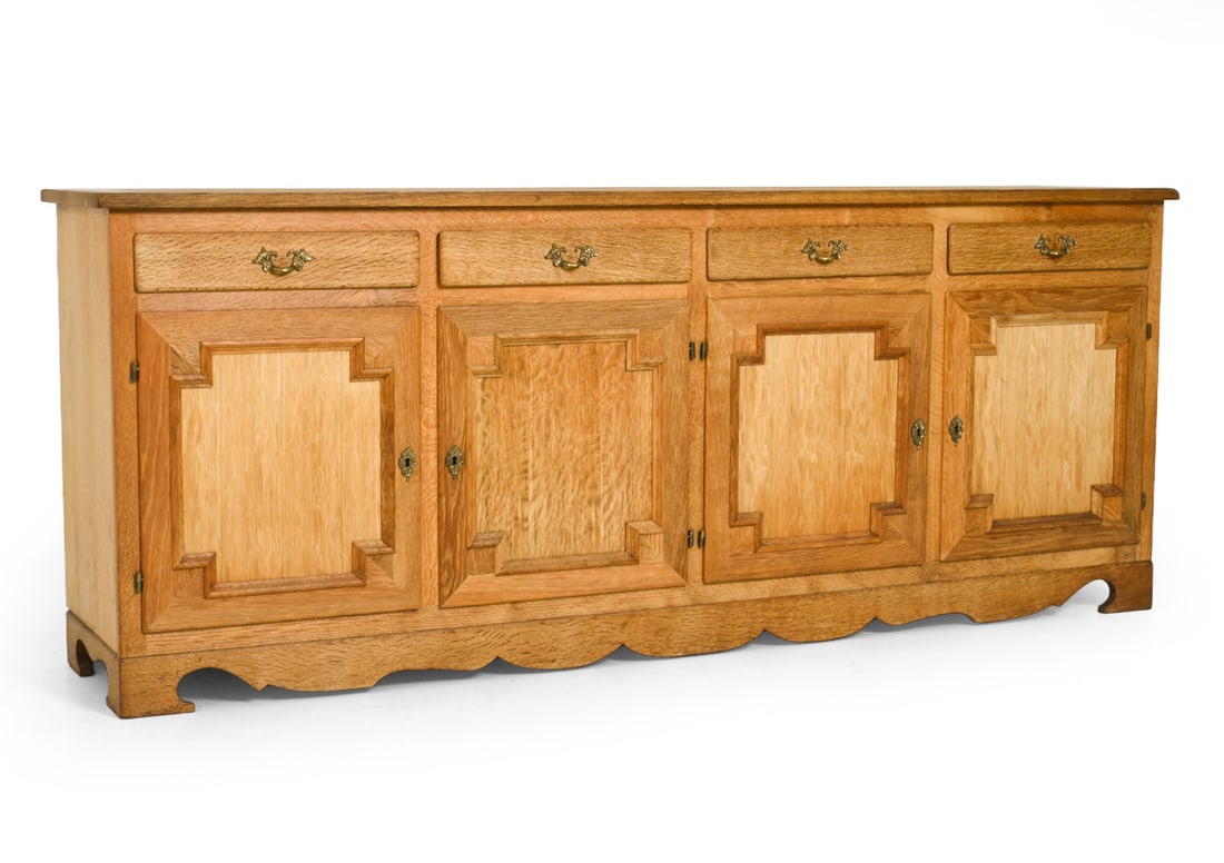HUNDSTRUP DANISH OAK SIDEBOARD C. 1970S: Key included. Tag remnants marked on backside. Carved oak with brass hardware. Denmark, circa 1970s. Dimensions: H 32" x W 72.5 " x D 17.25 " Condition: Light surface wear consistent with age and