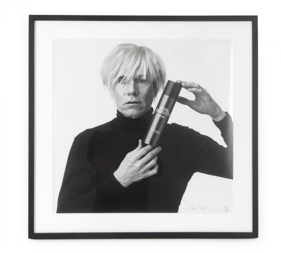 ANDREW UNANGST (B. 1950) ANDY WARHOL VIDAL SASSOON: Photographic print of Andy Warhol posing with a can of Vidal Sassoon Hairspray for men. Signed, numbered 4/55 lower right. Circa 1985. Dimensions: (Frame) H 31.5" x W 30.5" (Sight) H 24" x W 23.25"