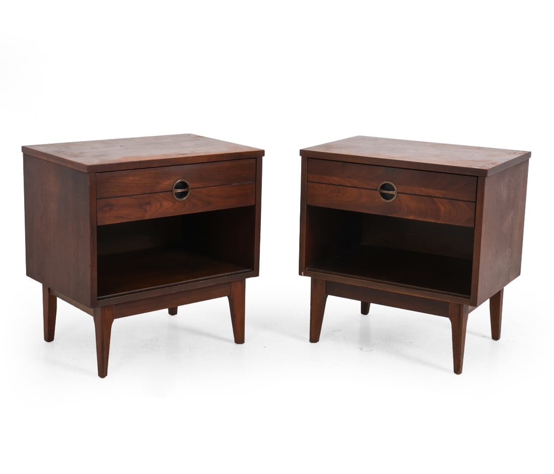PAIR OF WALNUT NIGHSTANDS C. 1960S: Walnut with tapered legs and recessed brass drawer pulls. Circa 1960s. Dimensions: H 23" X W 22" X D 15" Condition: Nicks, discoloration, watermarks, and wear to finish. Wear consistent with age and