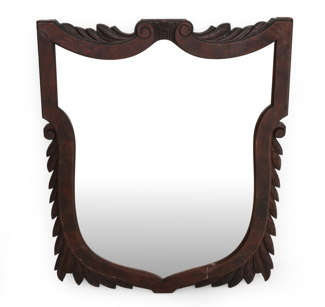 ANTIQUE MAHOGANY WALL MIRROR: Shield-shaped wall mirror featuring ornate leaf and scroll carvings along the frame. Dimensions: H 33.5" x W 26.75" Condition: Wear consistent with age and use. Scratches, rubs, minor finish loss to