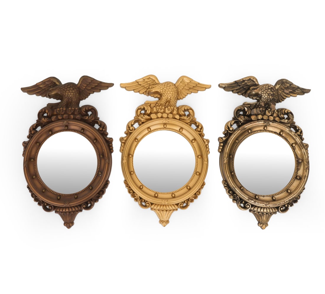 SYROCO EAGLE CONVEX MIRROR GROUPING: (3) mirrors total. One mirror has label one verso. Outstretched American eagle crest top, a circular bullseye/convex mirror glass, and decorative foliate scroll pendant bottom. USA, circa 1960s. Dimen