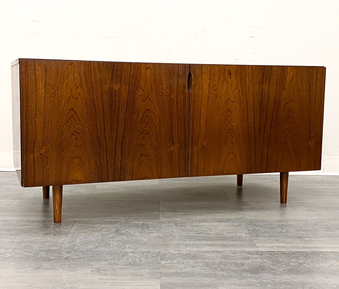 OMANN JUN STYLE DANISH ROSEWOOD CABINET C. 1960S: Two-door cabinet in rosewood. Denmark, circa 1960s. Dimensions: H 23" x W 47.25" x D 19.75" Condition: Wear consistent with age and use. Sun fading, scuffs, loss to finish, discoloration, nicks, some 