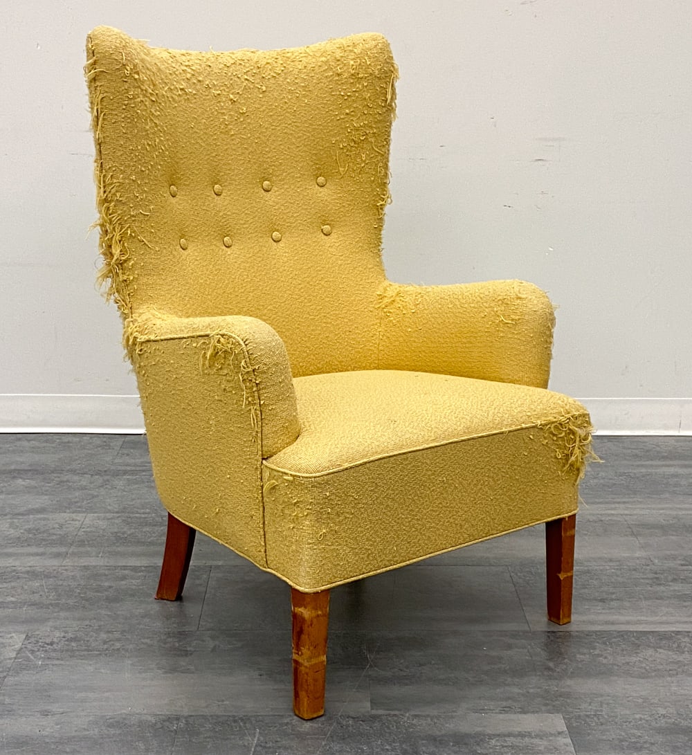 FRITZ HANSEN STYLE DANISH WINGBACK LOUNGE CHAIR: Tufted backrest and stained beech legs. Denmark, circa 1940s. Dimensions: H 42" x W 27" x D 30" x SH 17.25" Condition: Wear consistent with age and use. Great candidate for reupholstering. Heavy frayi