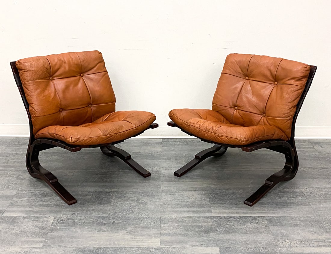 PAIR INGMAR RELLING FOR WESTNOFA "SIESTA" CHAIRS: Stained beech frame and tufted leather upholstery. Apparently unmarked. Norway, circa 1970s. Dimensions: H 31" x W 25" x D 28" x SH 18.25" Condition: Wear consistent with age and use. Fading, creasing