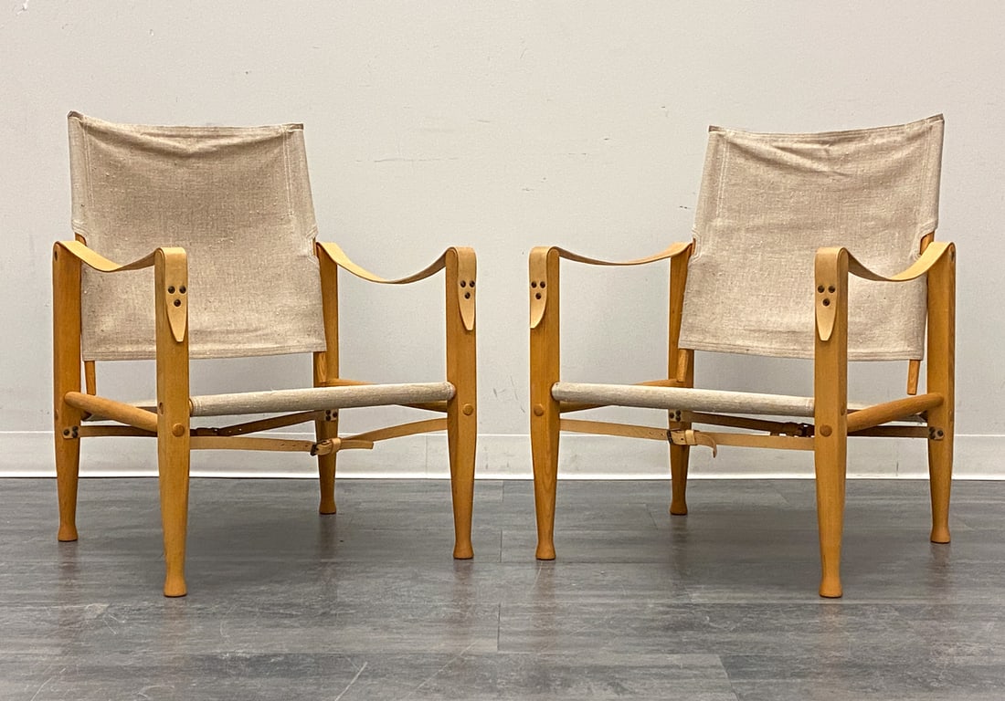 PAIR OF KAARE KLINT "SAFARI" LOUNGE CHAIRS 1960S: For Rud Rasmussen. Beech frame with leather straps and canvas sling for back and seat. Apparently unmarked. Denmark, circa 1960s. Dimensions: H 32" x W 22.5" x D 22.5" x SH 12.5" Condition: Wear consi
