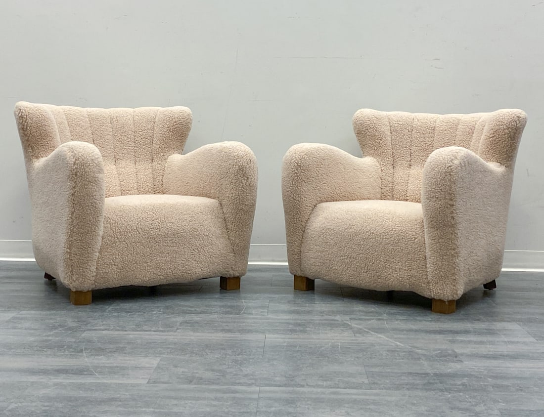 PAIR ATTR. FRITZ HANSEN LAMBSWOOL LOUNGE CHAIRS: Lambswool upholstery and oak legs. Denmark, circa 1940s. Dimensions: H 33" x W 29" x D 28" x SH 16" Condition: Recently reupholstered, Wear consistent with age and use. Minor scuffs to legs.