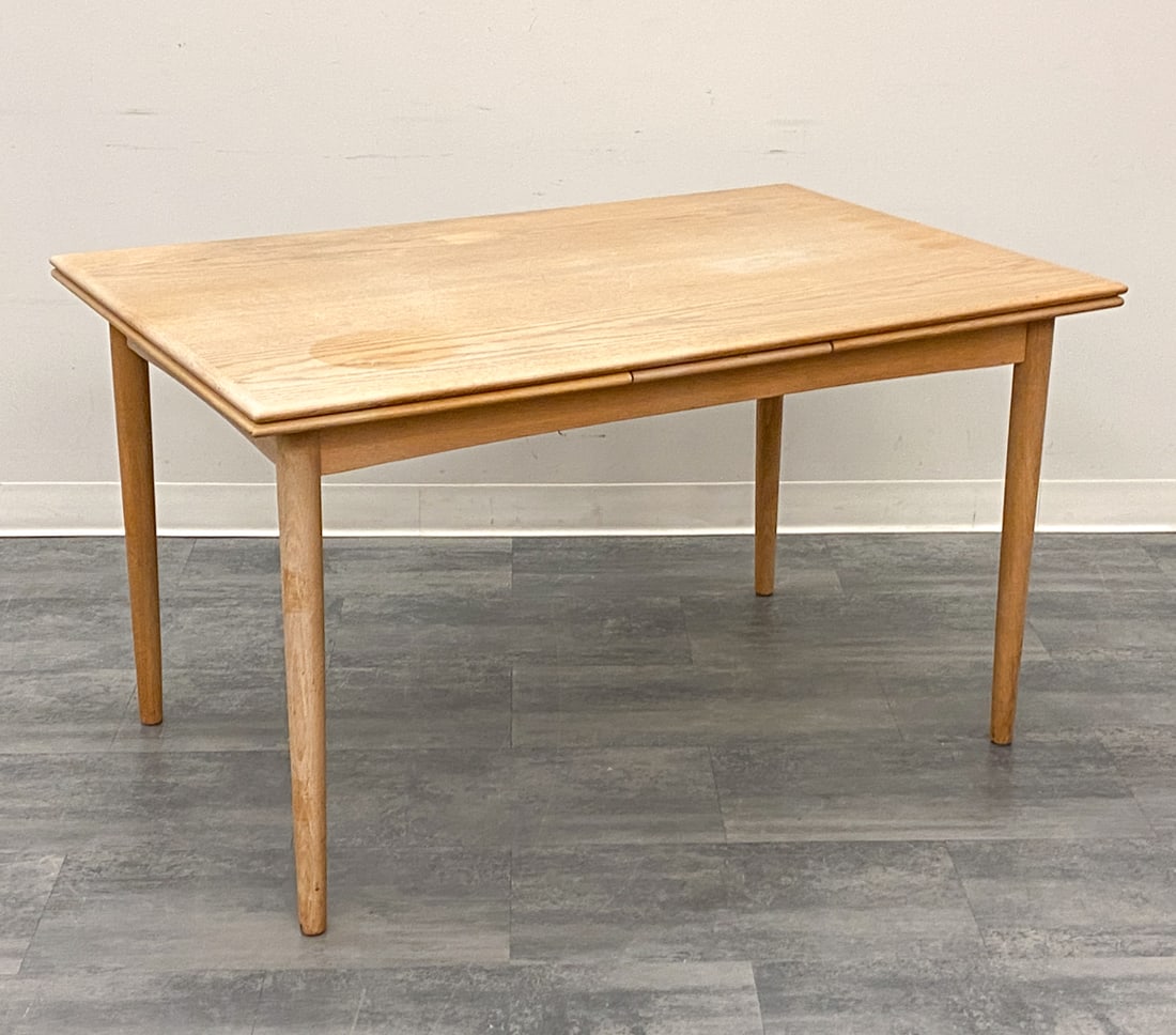 DANISH OAK EXTENDING DINING TABLE C. 1960S: Features two leaves for extension within table. Denmark, circa 1960s. Dimensions: H 29" x W 51" x D 34" Condition: Wear consistent with age and use. Fading, scuffs, some soiling, discoloration, waterm