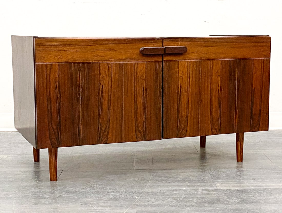 DANISH ROSEWOOD CABINET C. 1960S: Two door cabinet with carved pulls. Denmark, circa 1960s. Dimensions: H 16" x W 39.25" x D 20.5" Condition: Wear consistent with age and use. Fading, scuffs, some nicks. Legs might not be original.