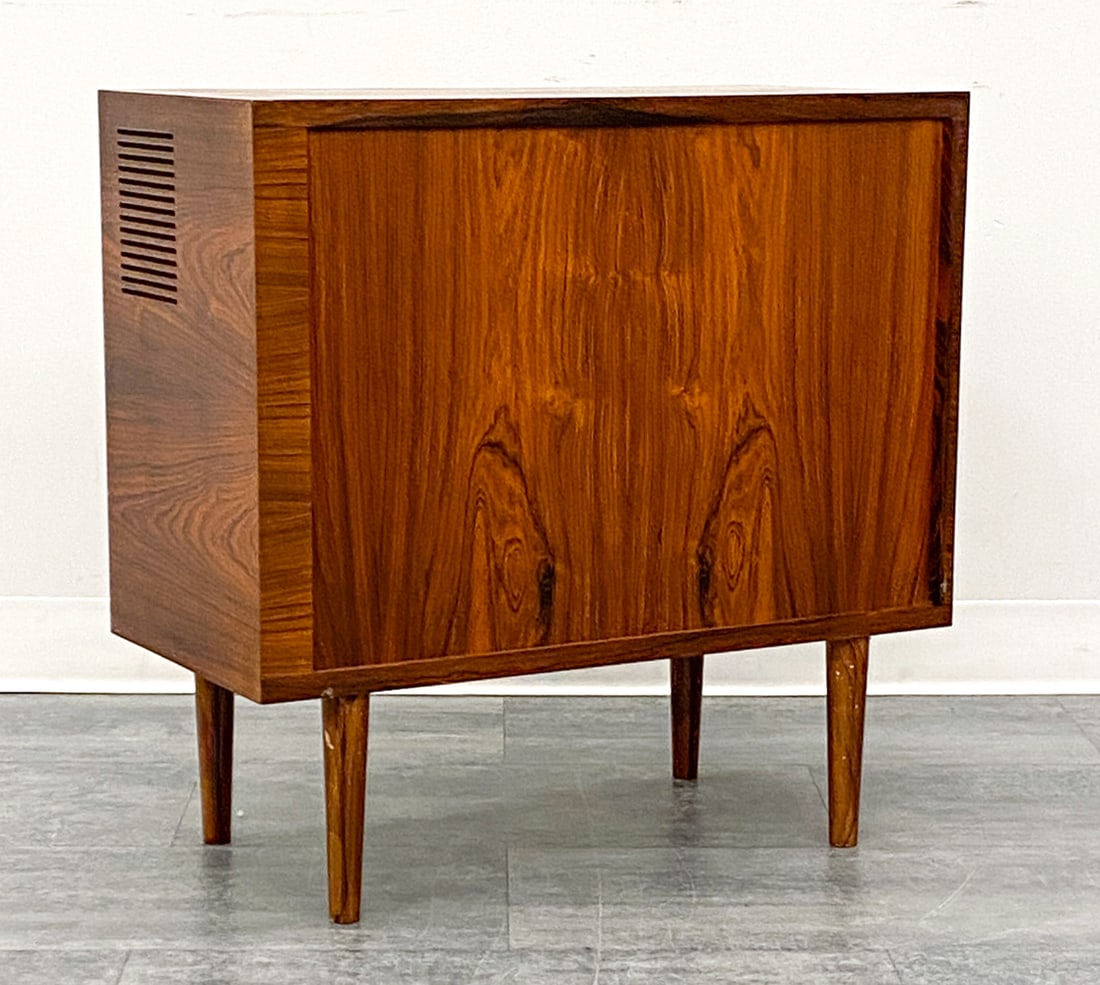 DANISH ROSEWOOD TAMBOUR MEDIA CABINET C. 1960S: Features tambour door that slide horizontally. Vented frame for use with electronics inside most likely Used as a TV cabinet. Denmark, circa 1960s. Dimensions: H 26.75" x W 27" x D 13" Condition: Wear