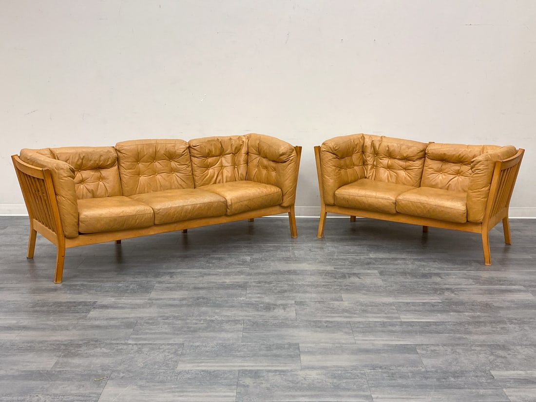 (2) STOUBY DANISH LEATHER SOFAS C. 1970S: Marked to underlining. Tufted tan leather cushions and beech frame. Two-seater and a three-seater sofa. Denmark, circa 1970s. Dimensions: (Largest) H 30.5" x W 87.5" x D 29.25" x SH 16" (Smallest) H 3