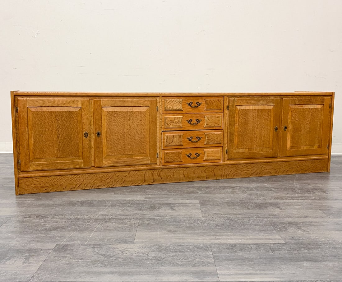 KJAERNULF STYLE DANISH OAK SIDEBOARD C. 1970S: Includes key. Carved oak and brass pulls with inlaid panel doors. Denmark, circa 1970s. Dimensions: H 23.75" x W 86.5" x D 19" Condition: Wear consistent with age and use. Fading, scuffs, watermarks, 