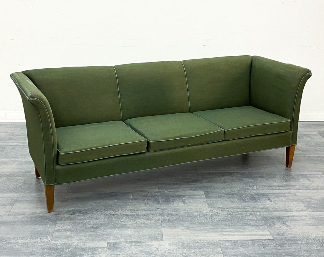 DUX STYLE SWEDISH SOFA C. 1960S: Oak legs and green upholstery. Sweden, circa 1960s. Dimensions: H 31.5" x W 79" x D 27.5" x SH 16" Condition: Wear consistent with age and use. Scuffs, severe distress to left armrest, fading. Nicks, 