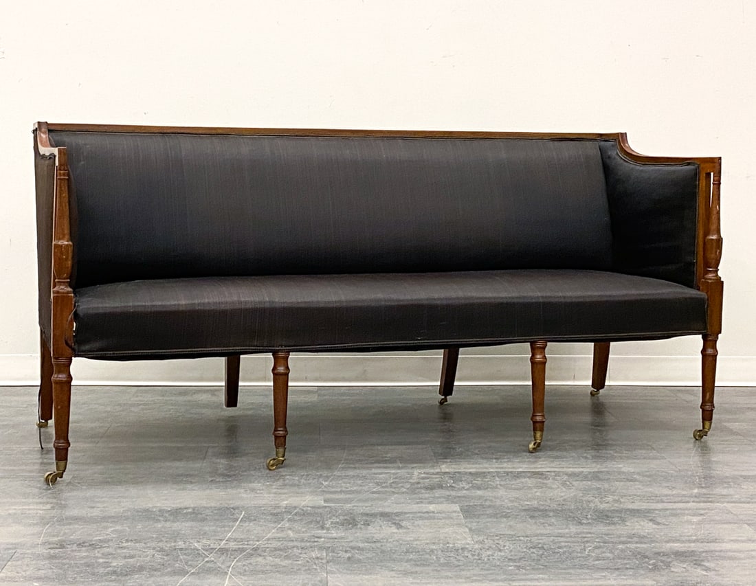 ENGLISH SHERATON STYLE MAHOGANY SOFA: Mahogany frame and legs with brass casters and dark-tone upholstery. Early 20th century. Dimensions: H 34.75" x W 72" x D 27.5" x SH 16.5" Condition: Wear consistent with age and use. Loose braid. Som