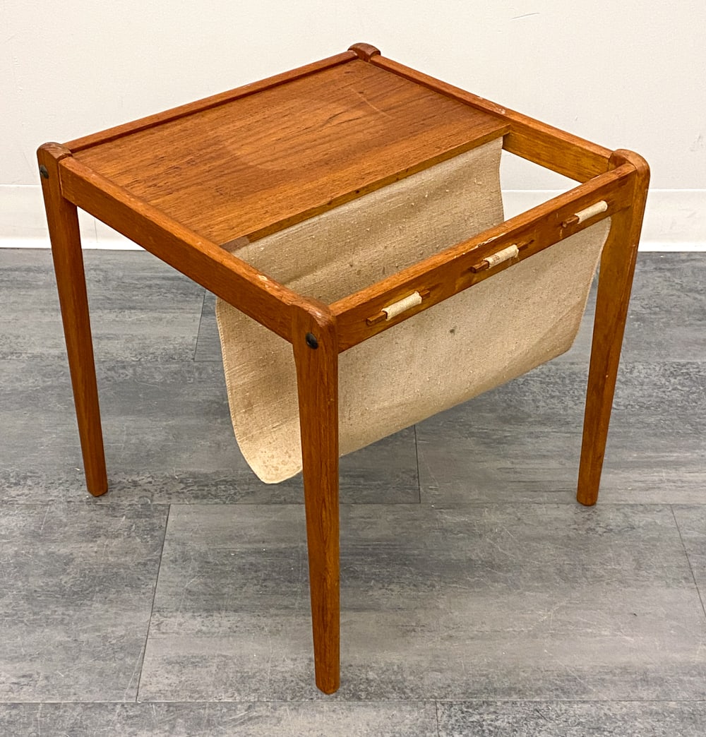 BRDR FURBO DANISH TEAK MAGAZINE RACK C. 1960S: Teak frame and canvas sling. Marked underneath. Denmark, circa 1960s. Dimensions: H 18" x W 18" x D 18" Condition: Wear consistent with age and use. Discoloration, fading, scuffs, watermarks, soiling,