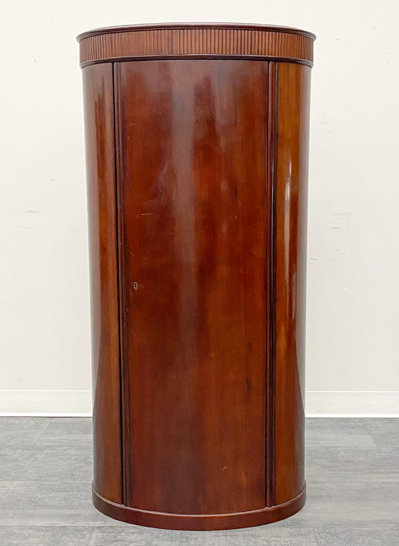 STYLE OF JOHANNES SORTH MAHOGANY PEDESTAL CABINET: Includes key. Features a curved door with keyhole. Denmark, circa 1960s. Dimensions: H 53" x W 26" x D 17" Condition: Wear consistent with age and use. Finish loss to shelves, scratches, soiling.