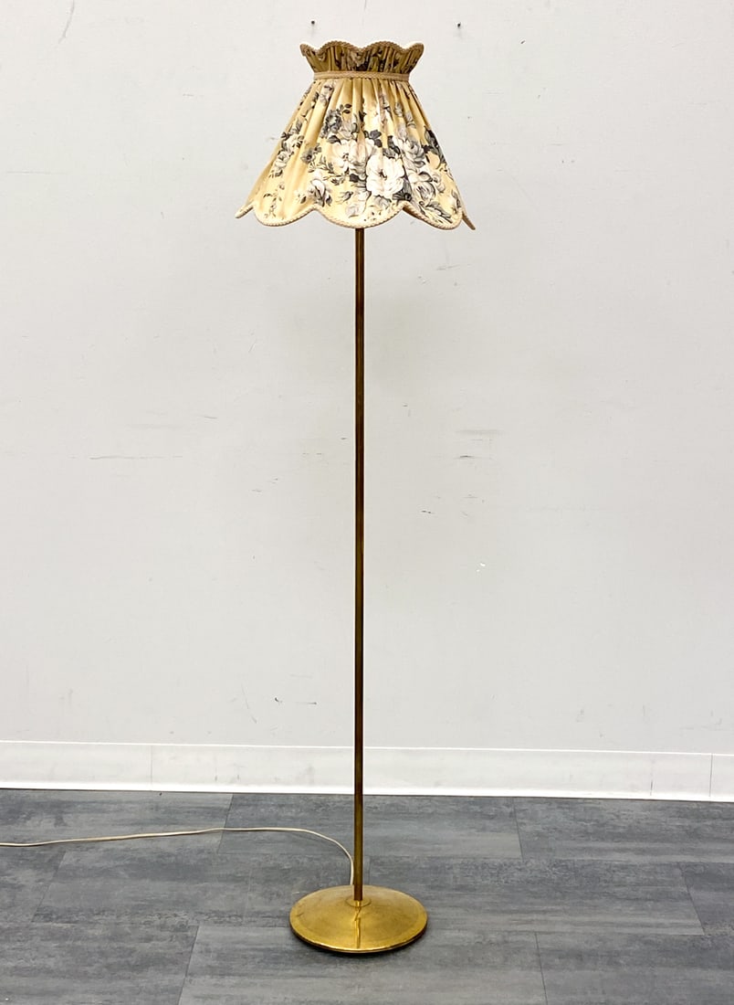 SCANDINAVIAN BRASS FLOOR LAMP C. 1950S: Floral-pattern shade and brass base. Scandinavian, circa 1950s. Dimensions: H 62" x Dia 15" Condition: Wear consistent with age and use. Untested, cord cut. Scuffs, patina. Shade rest shows signs of p