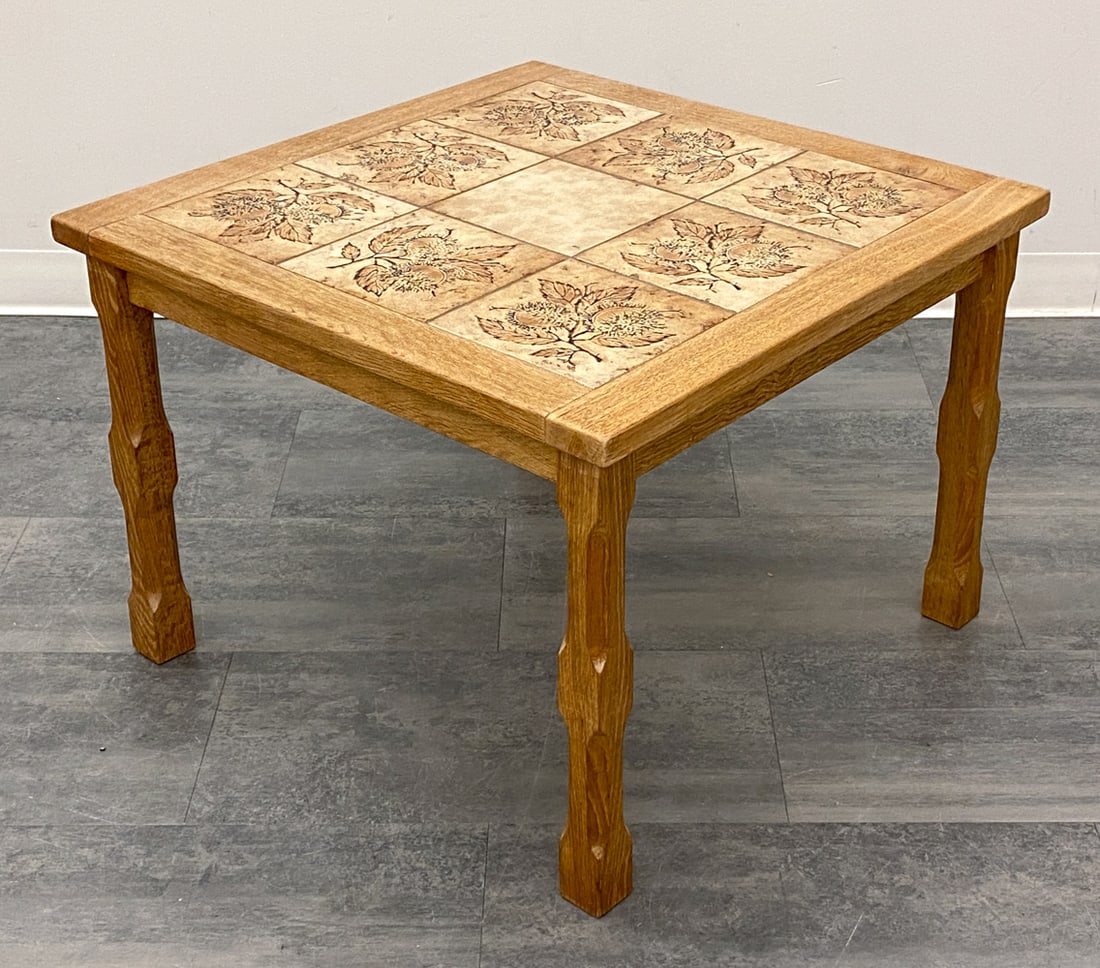 STYLE OF KJAERNULF DANISH OAK & TILE COFFEE TABLE: Tile top and carved oak frame. Denmark, circa 1970s. Dimensions: H 21" x W 29" x D 29" Condition: Wear consistent with age and use. Scuffs, fading, discoloration.