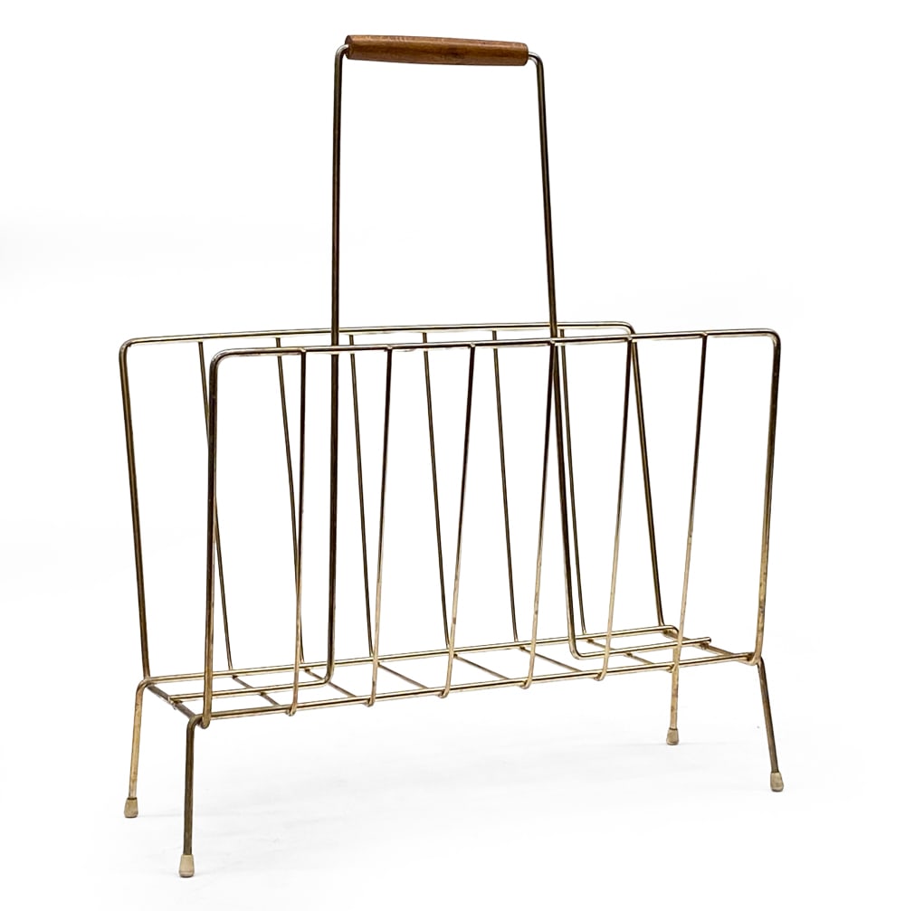 SCANDINAVIAN MAGAZINE RACK C. 1960S: Brass tone metal magazine rack with teak handle. Dimensions: H19" x W 14.5" x D 7.5" Condition: Wear consistent with age and use. Discoloration to handle. Scuffs and scratches.