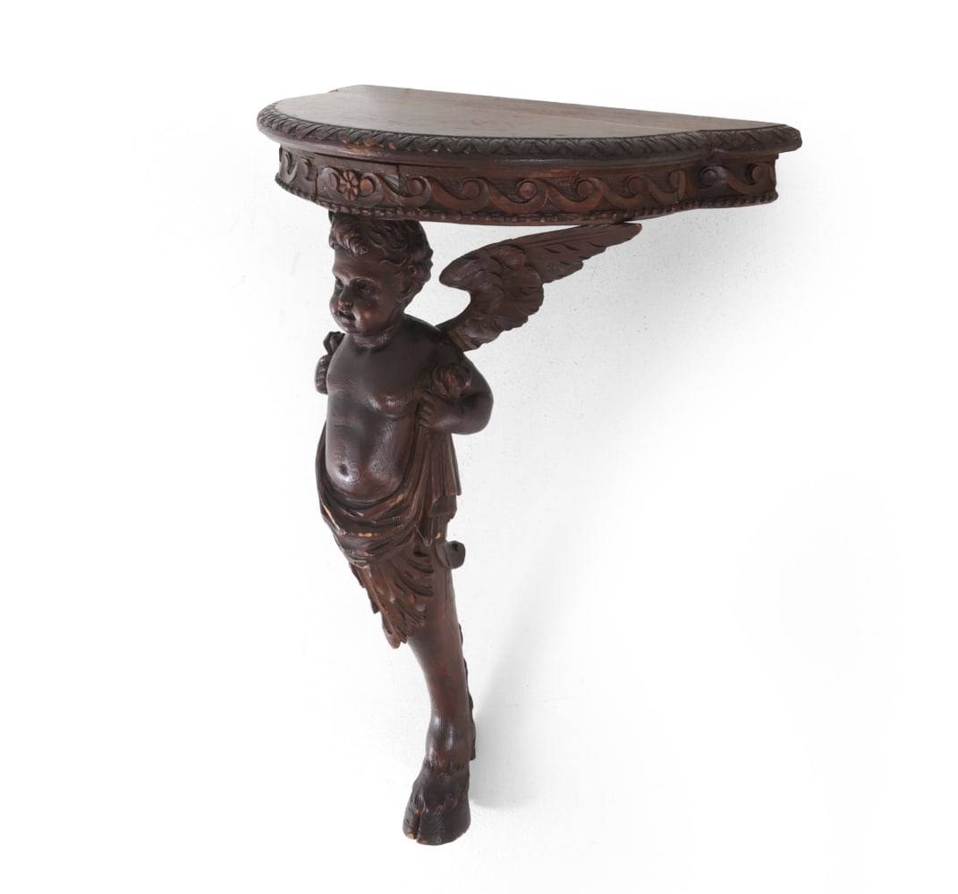 19TH C. WINGED PUTTI FIGURAL WALL SHELF: Wall mounted shelf with carved scroll and floral decoration, supported by a winged figure. Dimensions: H 31.5? x W 21? x D 13? Condition: Some cracks, discoloration and scuffs, wear consistent with ag