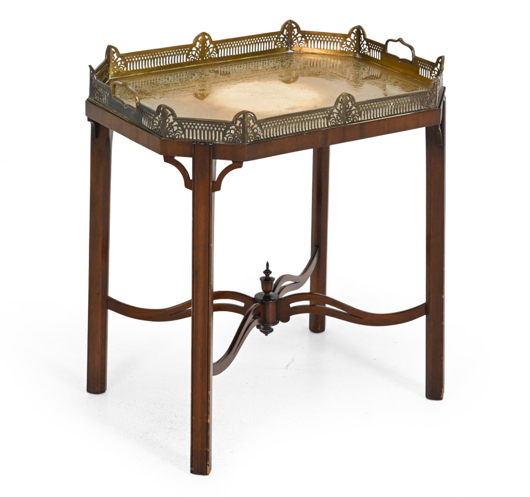 GEORGIAN STYLE MAHOGANY TRAY TOP TABLE: Mahogany with carved stretcher base and brass fretwork top. 20th century. Dimensions: H 25.75''x W 24''x D 18'' Condition: Scratches on the top. Minor scuffs. Discoloration. Consistent to age and use.