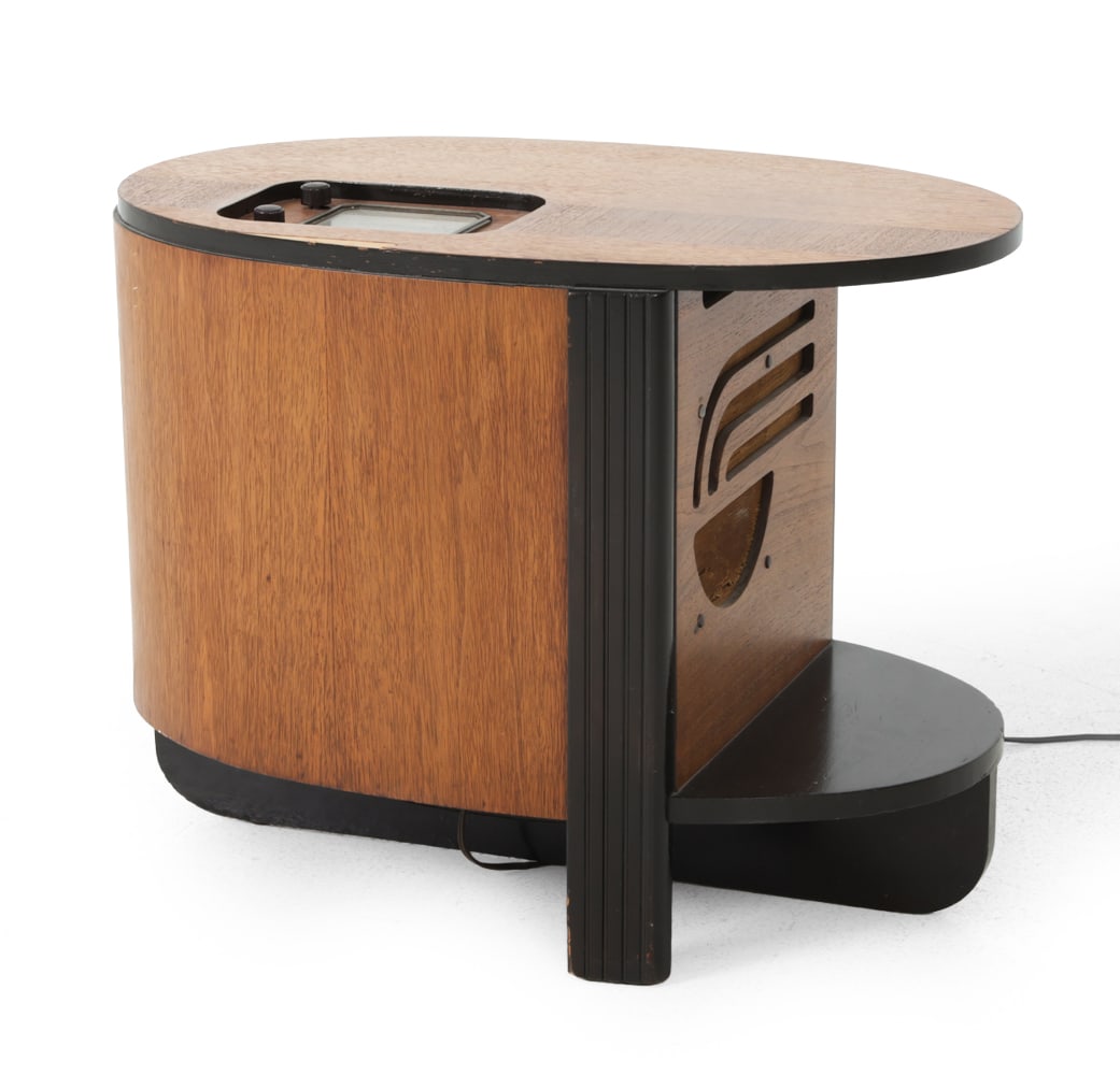 ART DECO PHILCO 39-7 C TUBE RADIO TABLE 1940S: Marked on the backside. Walnut and black-finished wood with cutouts for radio audio and top radio control unit. Circa 1940s. Dimensions: H 19" x W 25 " x D 16 " Condition: Showing signs of wear consis
