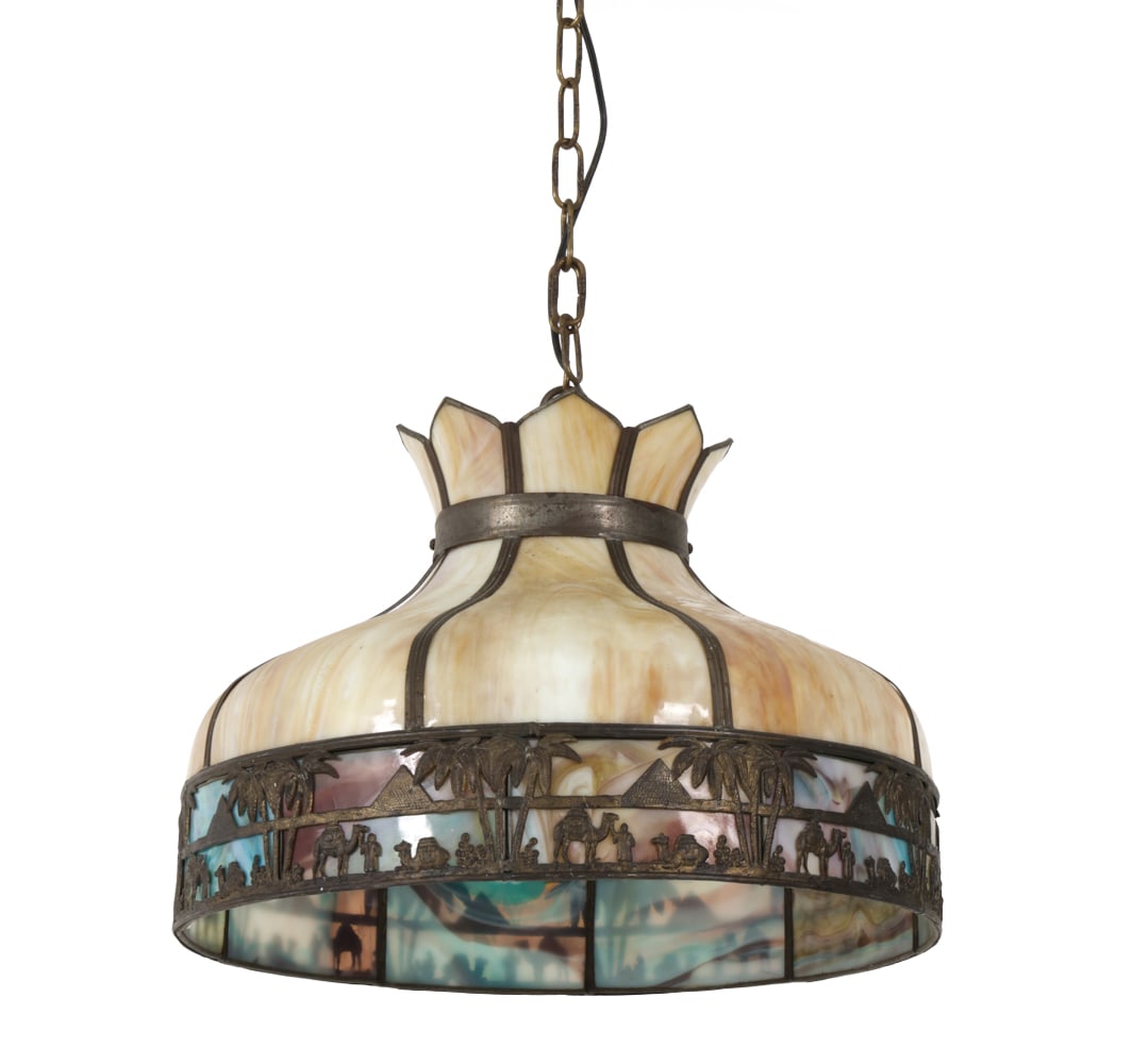 EGYPTIAN REVIVAL STYLE SLAG GLASS CHANDELIER: Egyptian Revival style hanging lamp with cream and caramel slag glass. Metal scenic frieze. Early 20th Century. Dimensions: H 38? x Dia 20 ? Condition: Some patina, wear consistent with age and use.