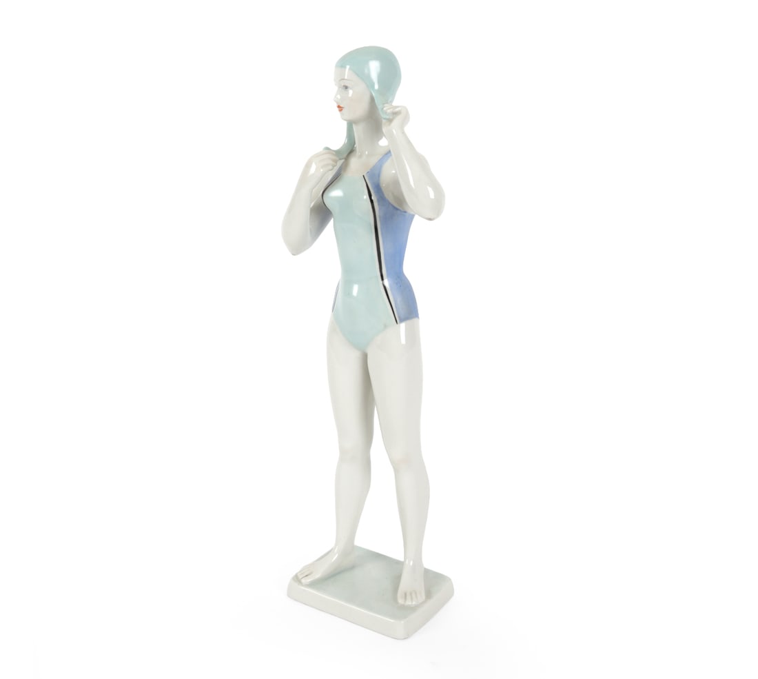 HUNGARIAN HOLLOHAZA SWIMMER PORCELAIN FIGURINE: Hand painted Hungarian porcelain Hollohaza art deco swimmer figurine. Marked to underside. 20th century. Dimensions: H 13" x W 5" x D 3" Condition: Minor scuffs. Wear consistent with use and age.