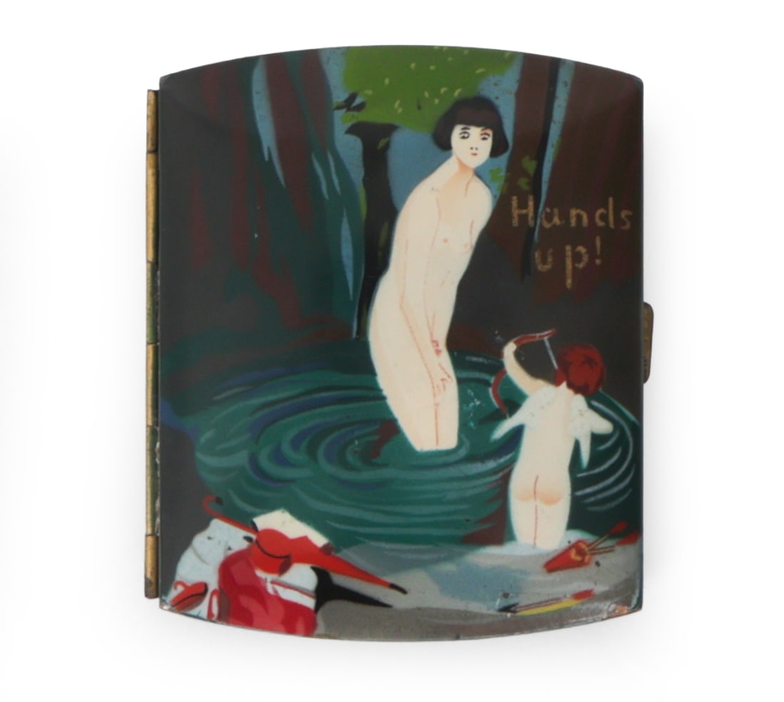 ART DECO NUDE ENAMEL CIGARETTE CASE C. 1920S: Features a playful hand painted bathing scene with the words "Hands up!". Circa 1920s. Dimensions: H 3" x W 3.5" Condition: Wear consistent with age and use. Oxidizing.