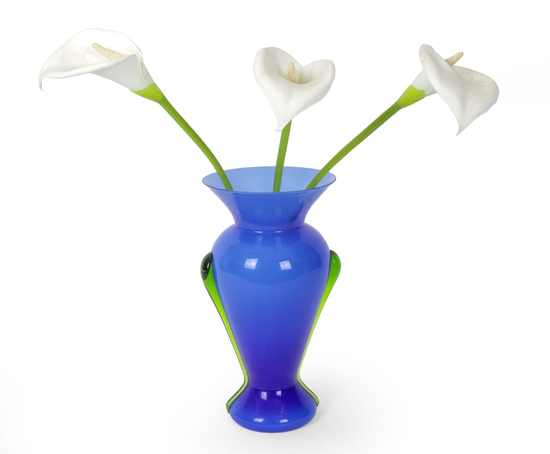VINTAGE ART GLASS VASE: Blue with green accents on the side. 20th century. Dimensions: H 13" x W 7" x D 6" Condition: Vase with very light handling wear. Small tear to one faux calla lily.