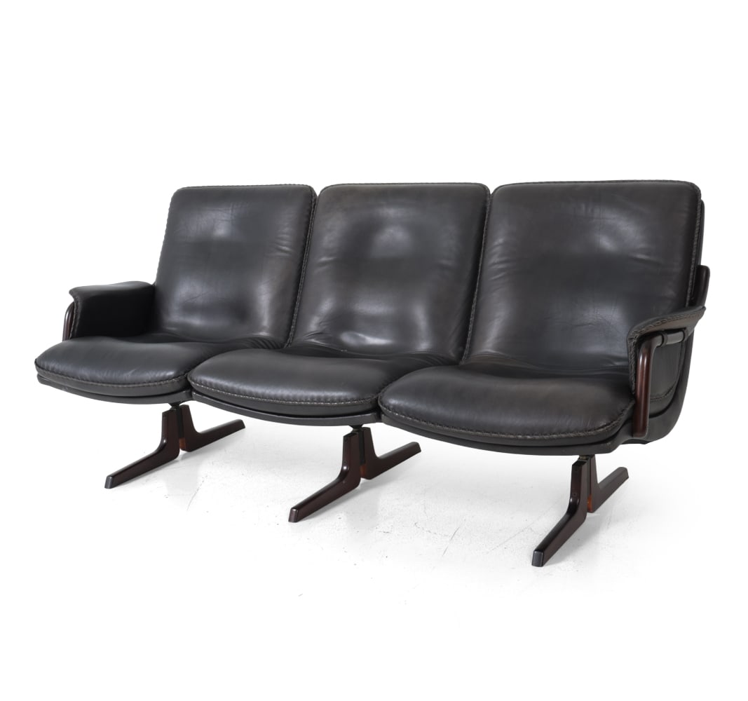 BERG FURNITURE DANISH LEATHER SOFA C. 1970S: Berg furniture three seat sofa black leather with braided edging on metal supports. Faint marker's mark to verso. Denmark Circa 1970s. Dimensions: H 33'' x W 75'' x D 27" x SH 16" Condition: Discolora