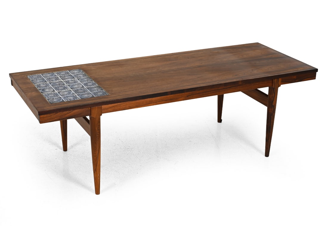 DANISH ROSEWOOD & TILE COFFEE TABLE C. 1970S: Rosewood with round tapered legs and blue inlaid tile detail. Denmark, circa 1970s. Dimensions: H 20'' x W 63.25'' x D 24" Condition: Light surface wear consistent with age and use. JE134