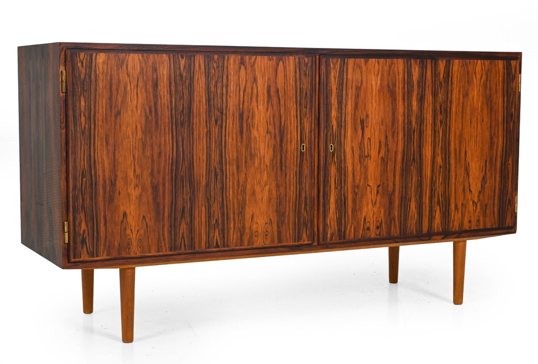 POUL HUNDEVAD ROSEWOOD SIDEBOARD C. 1960S: Key included. Rosewood with tapered legs and interior storage. Interior drawers are lined with green felt. Denmark, circa 1960s. Dimensions: H 29.5'' x W 54.8'' x D 17" Condition: Minor scuffs, some s