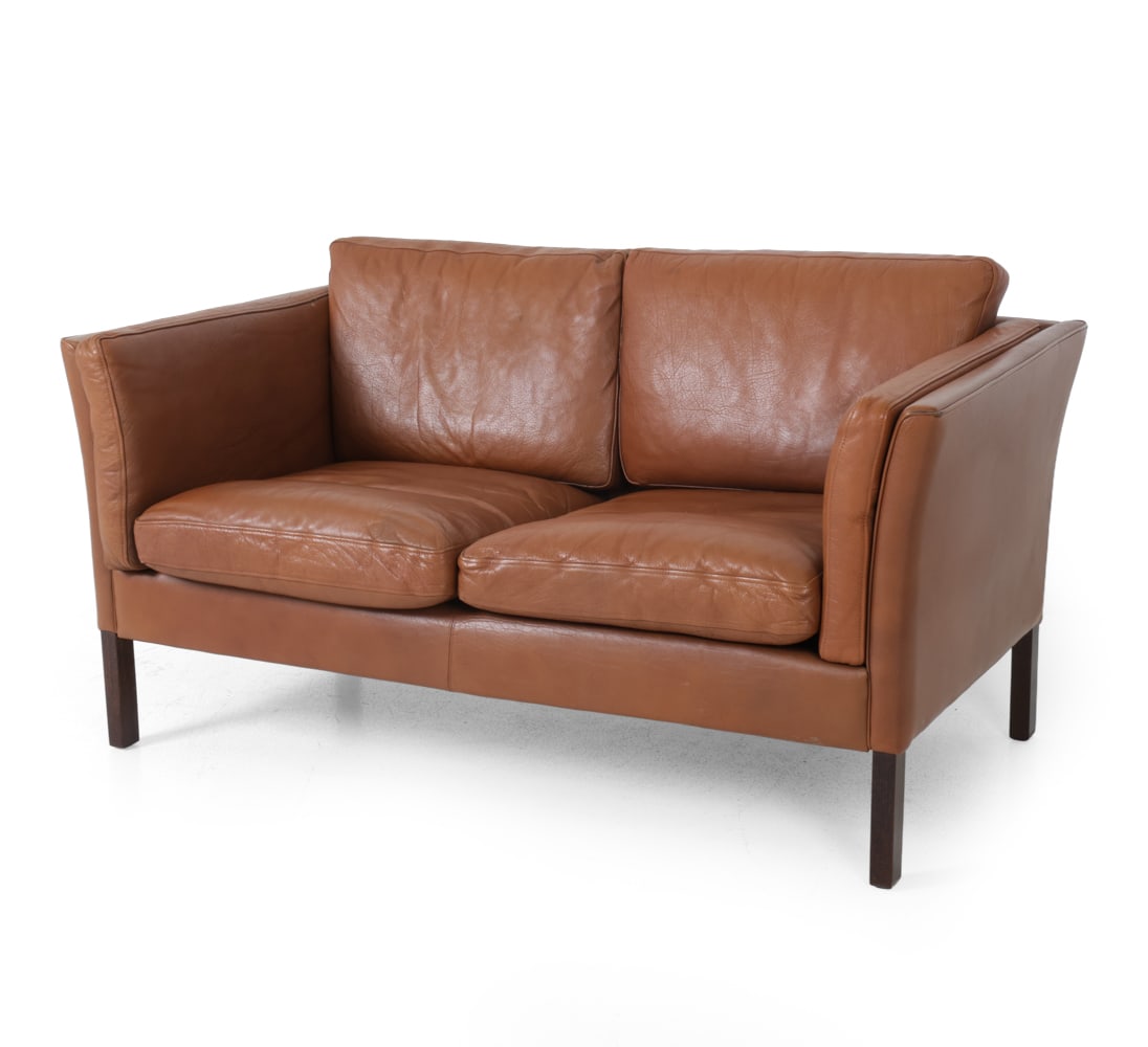 MOGENS HANSEN DANISH LEATHER LOVESEAT SOFA 1970S: Two seater loveseat sofa with leather upholstery and stained beech legs. Apparently unmarked. Denmark, circa 1970s. Dimensions: H 26.5'' x W 56.5'' x D 31" x SH 18" Condition: Some scuffs, stains and 