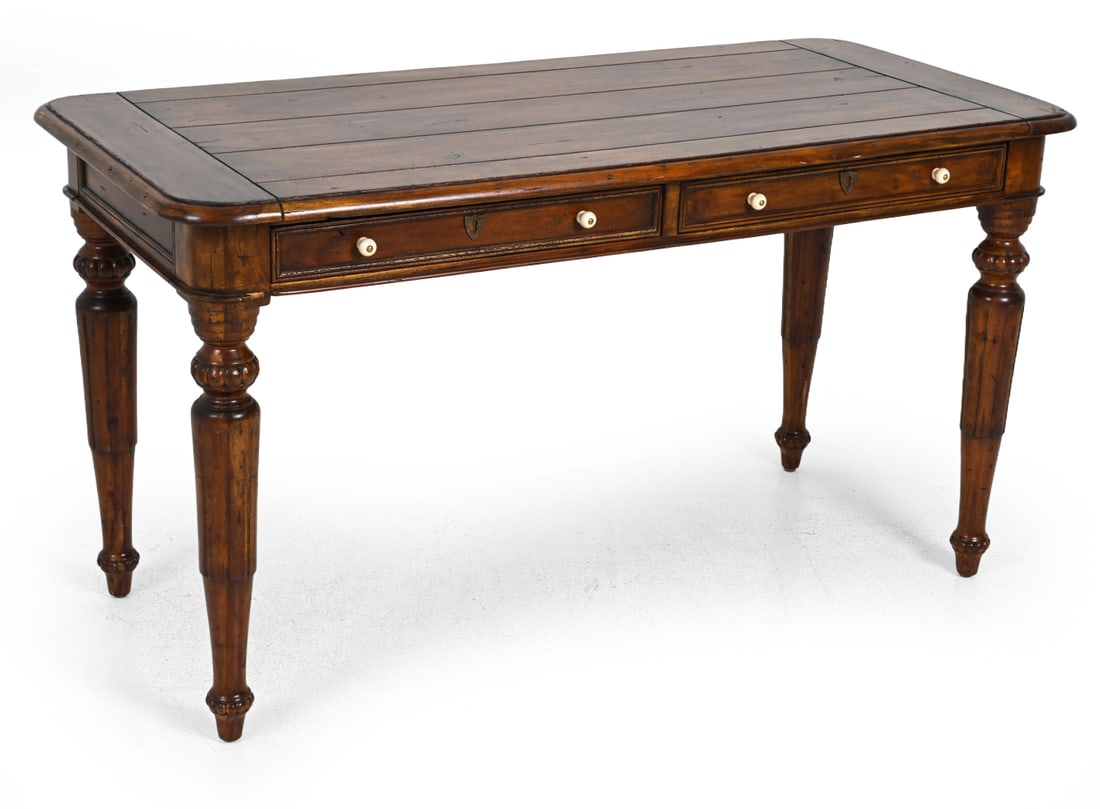 LILLIAN AUGUST "CHALET" WALNUT WRITING DESK: Marked underneath. Carved wood with turned legs and two drawers. Dimensions: H 32''x W 59''x D 28'' Condition: Loss to front. Scuffs and scrapes. Intentionally distressed as well as minor wear/damage.