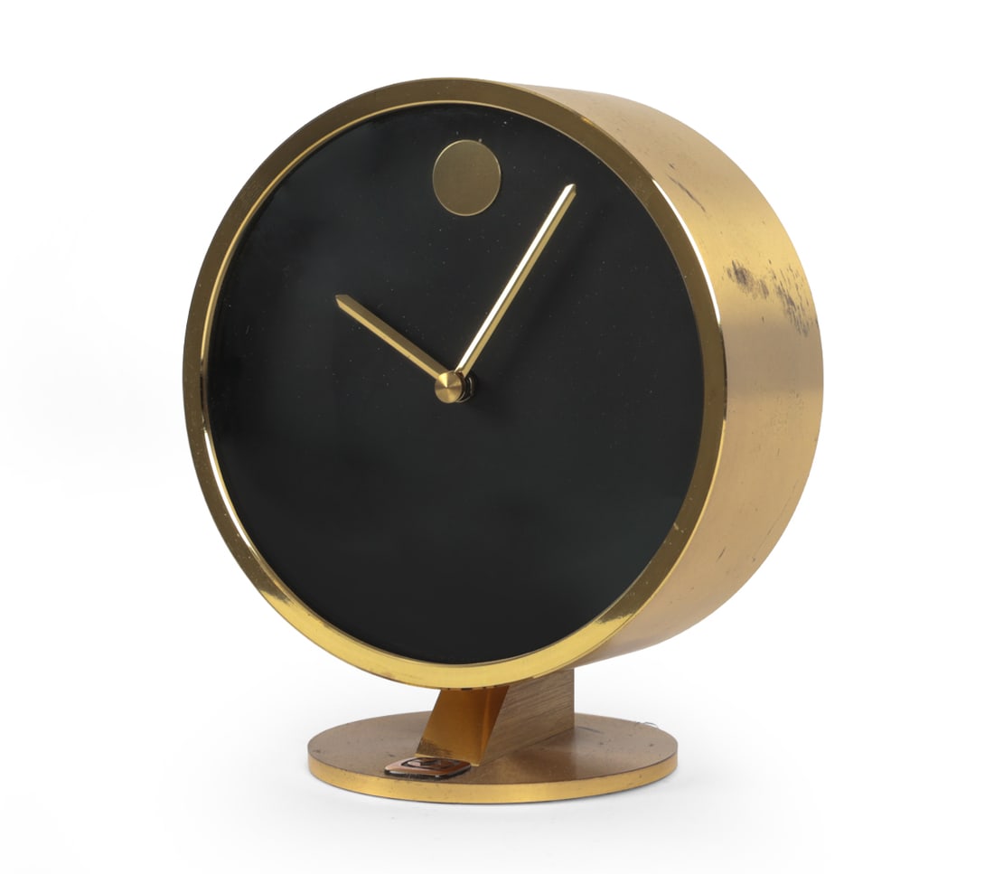 HOWARD MILLER NATHAN HORWITT BRASS MUSEUM CLOCK: Howard Miller brass "Museum" desk clock designed by Nathan George Horwitt, with cylindrical brass case. Dimensions: H 5.5" x W 4.75" x D 3 " Condition: Showing signs of wear including scuffs and