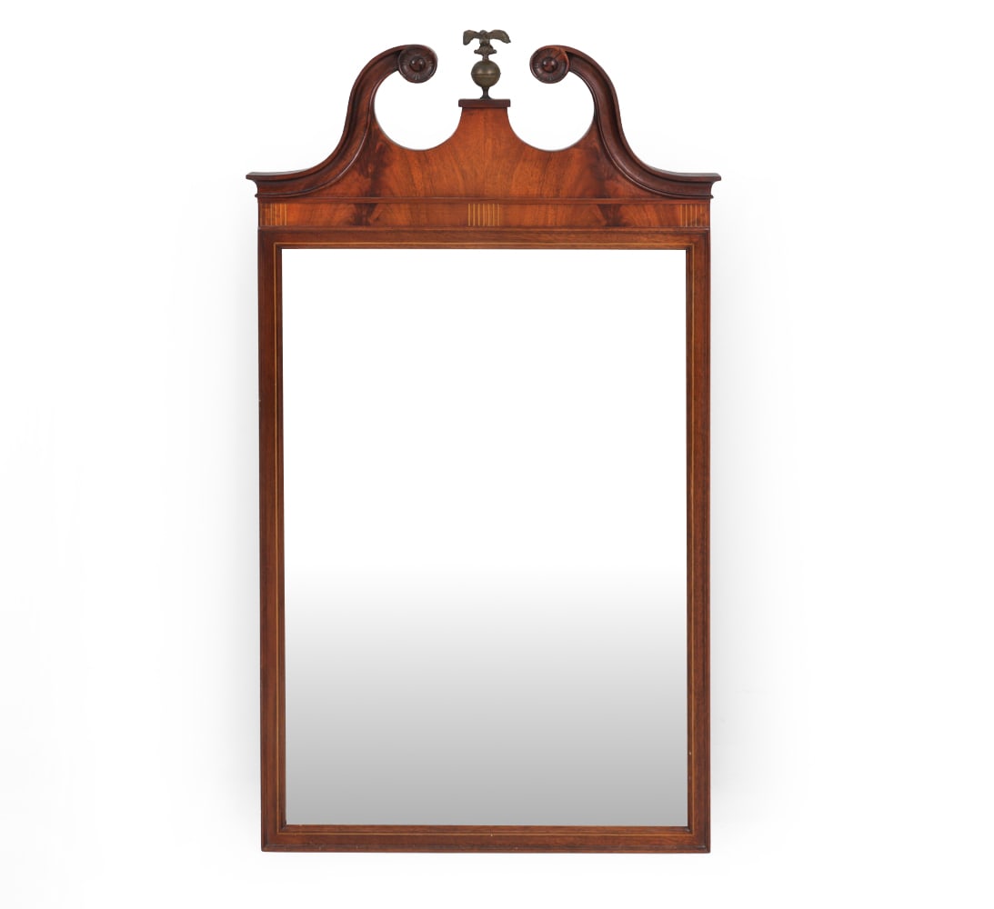 FEDERAL STYLE MAHOGANY WALL MIRROR: Federal style mahogany wall mirror with carved scroll cresting, central brass eagle finial, and line inlaid frieze. Dimensions: H 44" x W 24.5" x D 2.4" Condition: Showing wear including patina