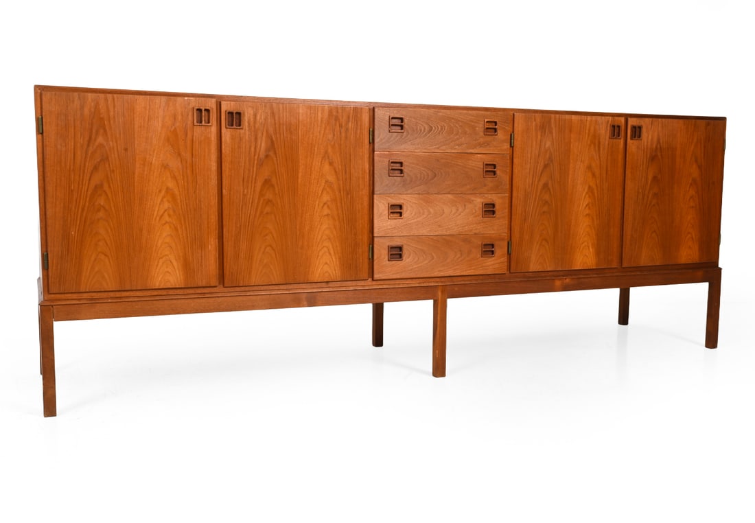 DANISH TEAK SIDEBOARD C. 1960S: Featuring four doors and drawers with carved recessed pulls. Apparently unmarked. Denmark, circa 1960s. Dimensions: H 34" x W 92? x D 21.5? Condition: Wear consistent with age and use. Sun fading, sma
