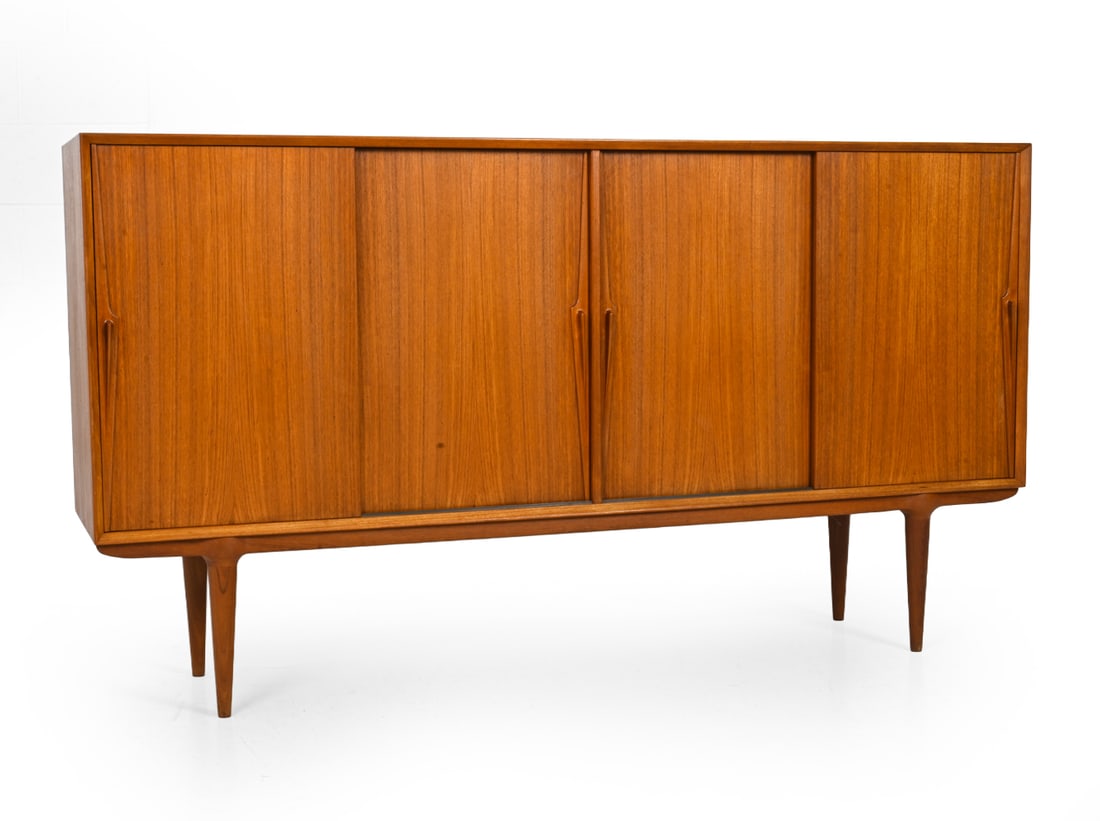 EDMUND JORGENSEN DANISH TEAK SIDEBOARD: Sideboard with Edmund Jorgensen label to back side. Sliding cabinet doors and sculpted pulls. Denmark, Circa 1960s. Dimension: H 43" x W 79" x D 18" Conditions: Scuffs , scratches to surface, water ma