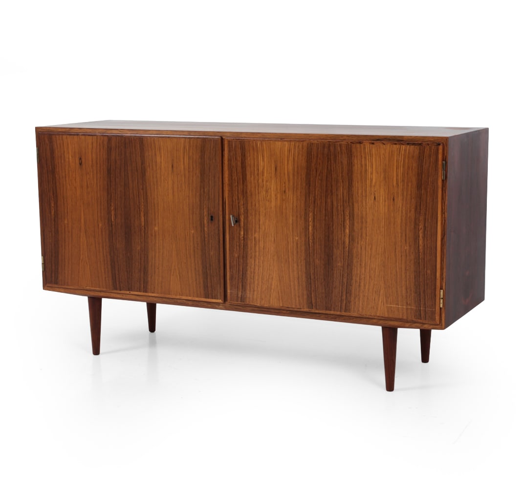 POUL HUNDEVAD DANISH ROSEWOOD CABINET C. 1960S: Includes key. Two-door cabinet. In rosewood. Marked to back. Denmark, circa 1960s. Dimensions: H 29.5 x W 54.5? x D 17.25? Condition: Sun fading, scratch on front door. Few small indents on top. Wear 