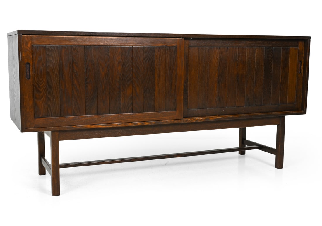 KURT OSTERVIG FOR K.P. MOBLER DANISH OAK SIDEBOARD: Stained oak sideboard with sliding doors designed by Kurt Ostervig for K.P Mobler. Marked to back. Denmark, circa 1960s. Dimensions: H 34" x W 71'' x D 20" Condition: Light surface wear consistent