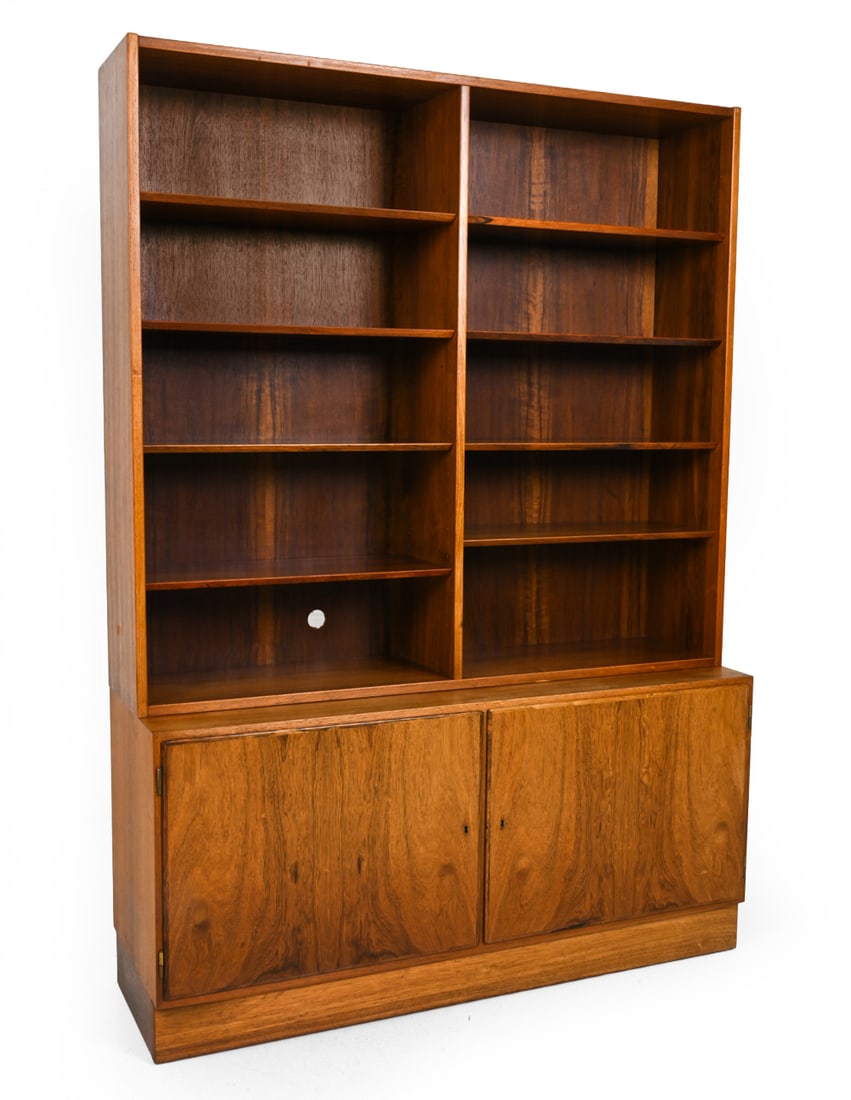 HUNDEVAD DANISH ROSEWOOD BOOKCASE CABINET: Key included. Two piece rosewood bookcase. Marked to frame. Denmark, circa 1960s. Dimensions: H 76.5 x W 17.5 ? x D 54.5? Condition: Heavy sun fading. Scuffs to top surface. Cut hole to the back. Mino