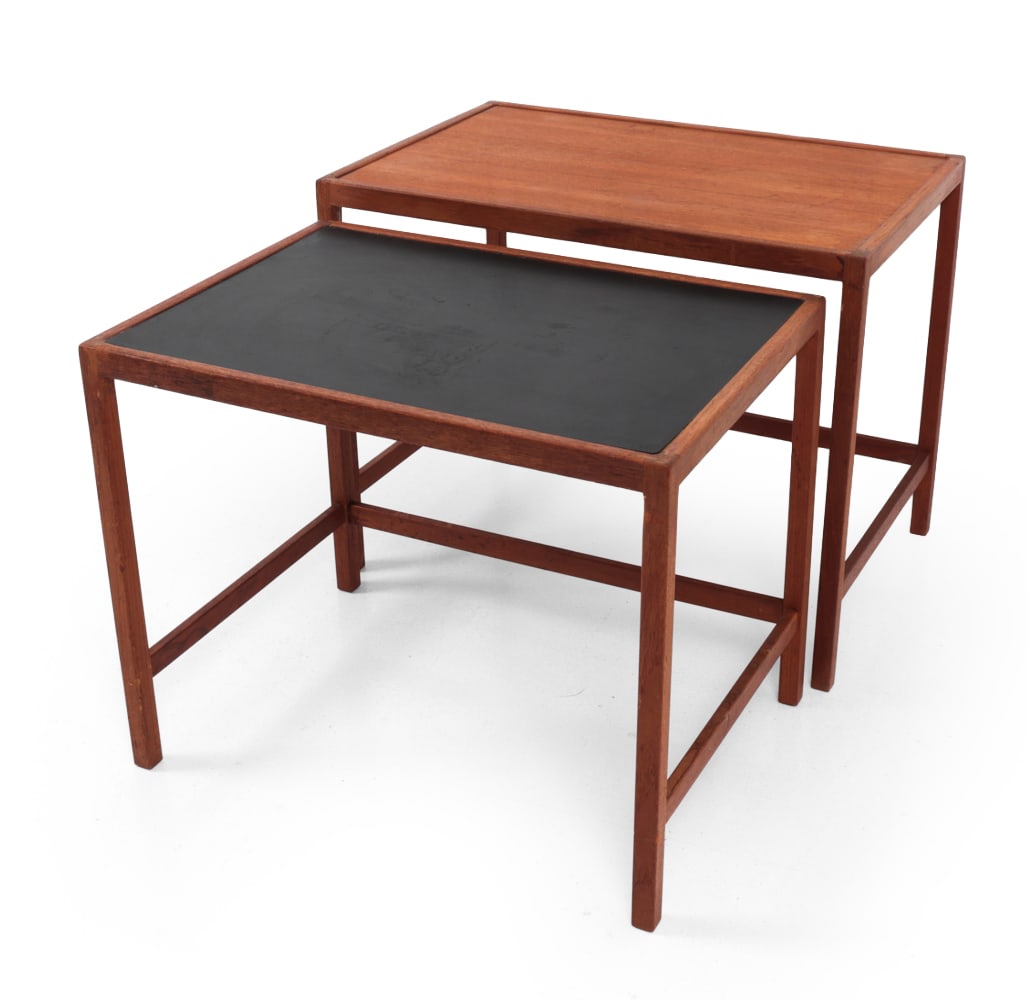 KURT OSTERVIG FOR JASON DANISH TEAK NESTING TABLES: (2) Teak nesting tables. One with a black laminated top. Apparently unmarked. Denmark, circa 1960s. Dimensions: (Largest) H 18.5" x W 23.75? x D 15.75? Condition: Hairline crack to corner of large tab
