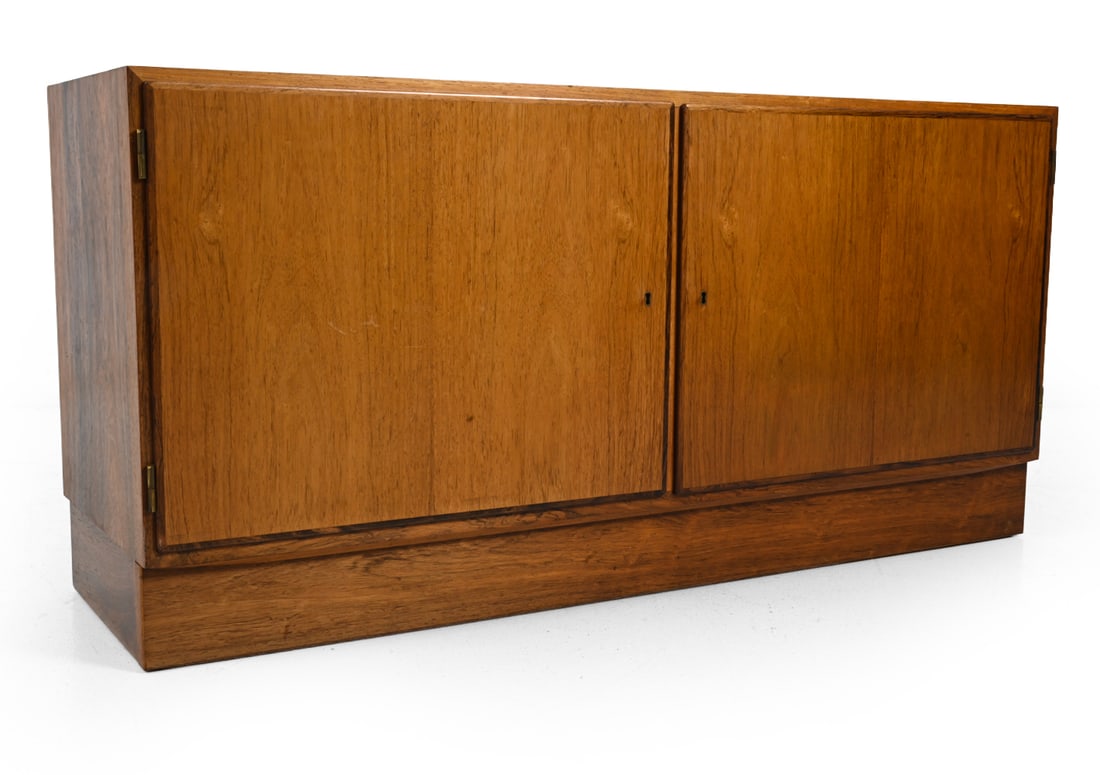 POUL HUNDEVAD DANISH ROSEWOOD CABINET C. 1960S: Includes key. Lockable doors with adjustable shelves and drawers inside. Marked on backside. Denmark, circa 1960s. Dimensions: H 26.25" x W 54.5" x D 17" Condition: Sun fading to top and doors. Scratc