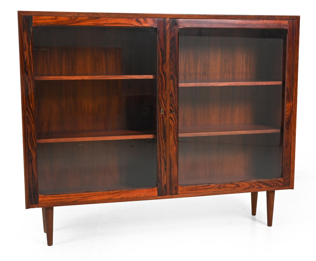 BROUER DANISH ROSEWOOD BOOKCASE CABINET: Rosewood veneer frame and glass doors. Denmark, Circa 1960s. Dimensions: H 42.75" x W 53.25" x D 12" Condition: Fading/discoloration. Scuffs and marks to top. Marked to back " Brouer - Made in Denmark