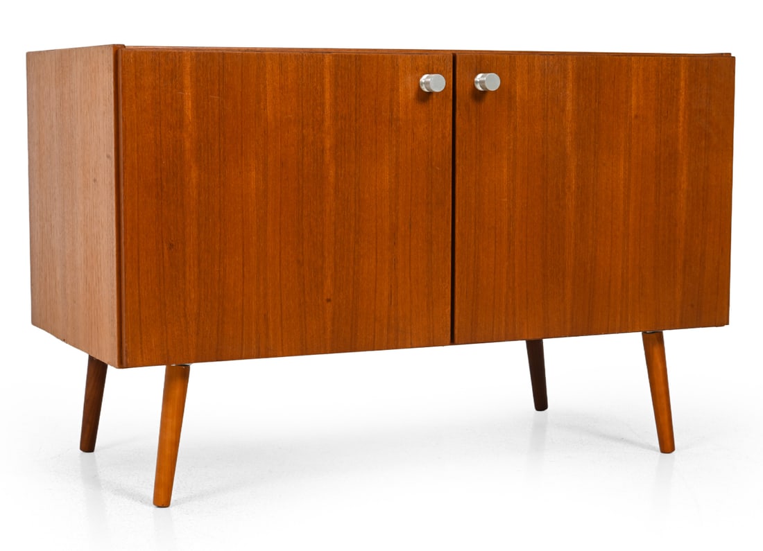 MID-CENTURY DANISH TEAK CABINET C. 1960S: Teak cabinet with aluminum pulls and interior shelves. Denmark, circa 1960s. Dimensions: H 20.5" x W 39.5" x D 21.5" Condition: Lacking a top section. Water stains to top, losses to veneer. Wear consi