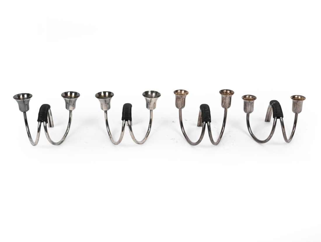 CARL F. CHRISTIANSEN SILVER PLATED CANDLEHOLDERS: (4) All are marked. Silver plated bent metal with black cord. Denmark, circa 1960s. Dimensions: H 2.5" x W 3" x D 2.75" Condition: Scuffs and tarnishing to silver. Wear consistent with age and use.