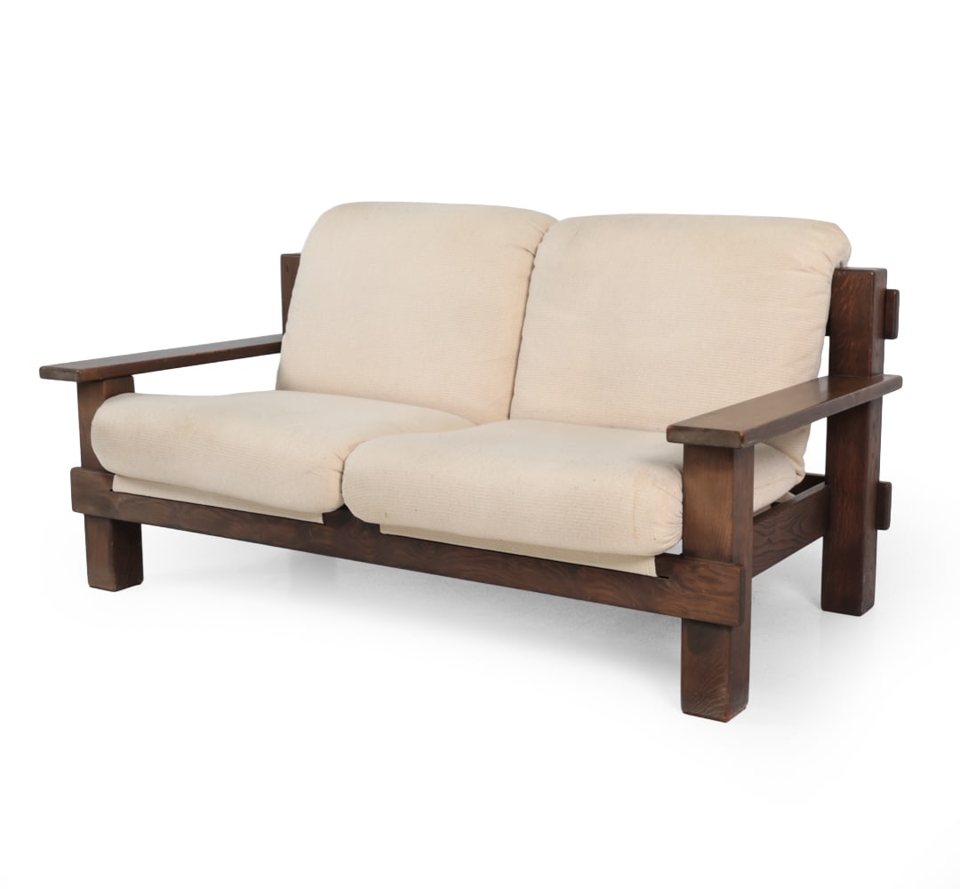 CARL STRAUB STYLE GERMAN OAK LOVESEAT SOFA 1960S: Oak frames. Cream woven seat and back cushions. Germany, circa 1960s. Dimensions: H 32'' x W 62.5'' x D 31" x SH 16'' Condition: Some scratches on the arm. Some scuffs to base. Discoloration. Wear