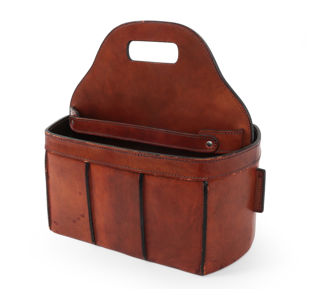 GERMAN TOP STITCHED LEATHER MAGAZINE CADDY 1970S: Brown leather with cut out carry handle. 20th century. Dimensions: H 16" x W 18? x D 10? Condition: Wear to leather edges some stains. Finish loss. Wear consistent with age and use.