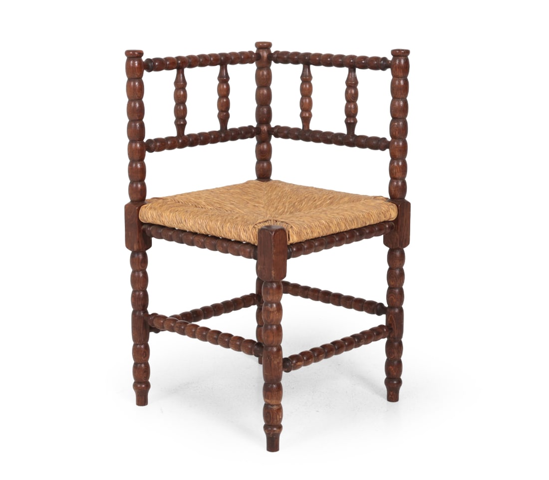 DUTCH BOBBIN TURNED OAK & RUSH CORNER CHAIR 1950S: Oak corner chair with stained finish and woven rush seat. Netherlands, circa 1950s. Dimensions: H 28.25? x W 16? x D 23?, SH 16.75 Condition: Few scuffs and scratches. Wear consistent with age and use